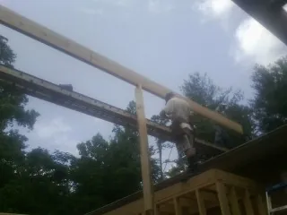 Carpenter setting a ridge beam over a new addition frame — Ice Dam Removal by Roofing Brothers in Lithopolis