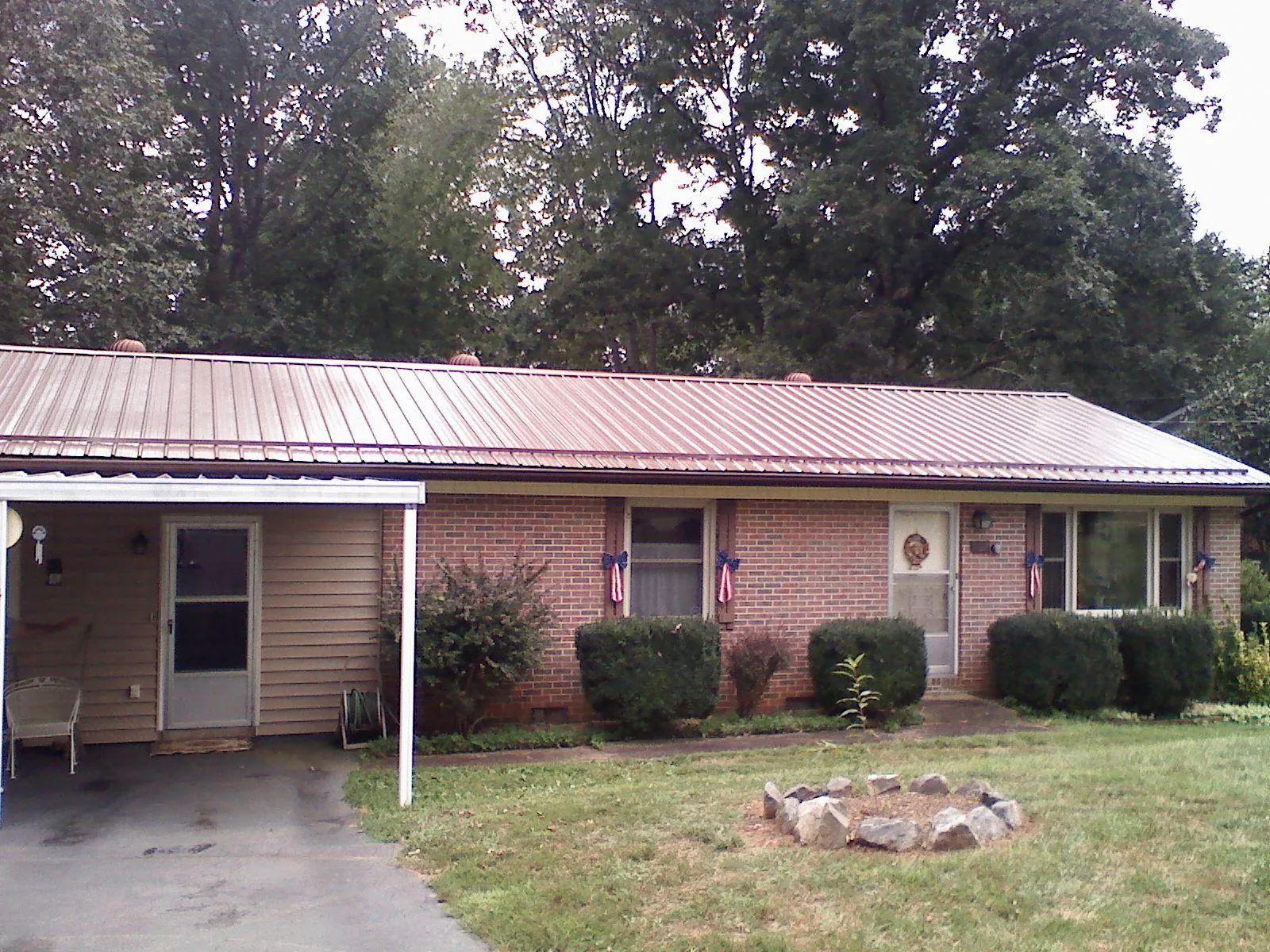 Bronze metal roof and carport on a brick ranch home — Roof Repair work by our crew in Lithopolis